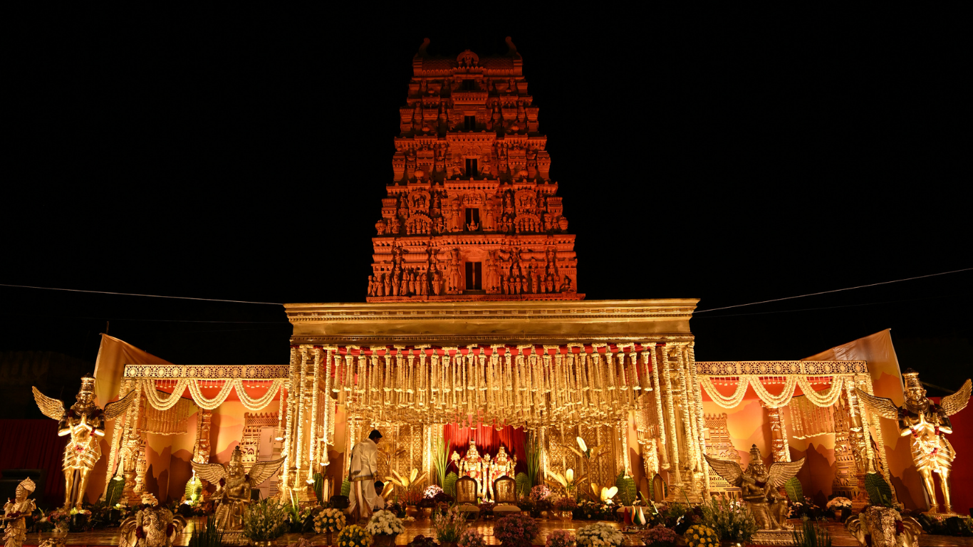 Night view of the full wedding stage decor with the temple gopuram behind it