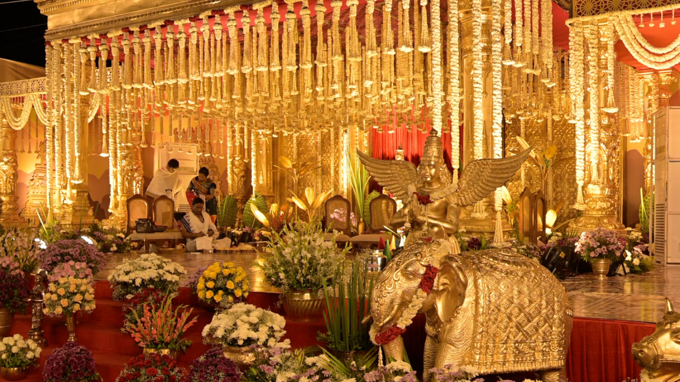 Lavish golden mandap with jasmine hangings, floral steps and elephant sculpture