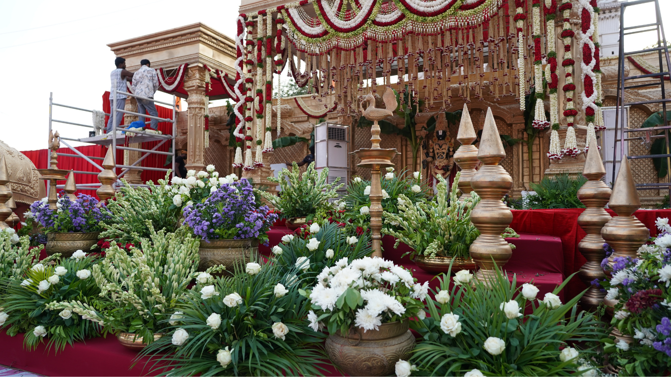 Grand mandap with red and white garlands and lush white floral arrangements