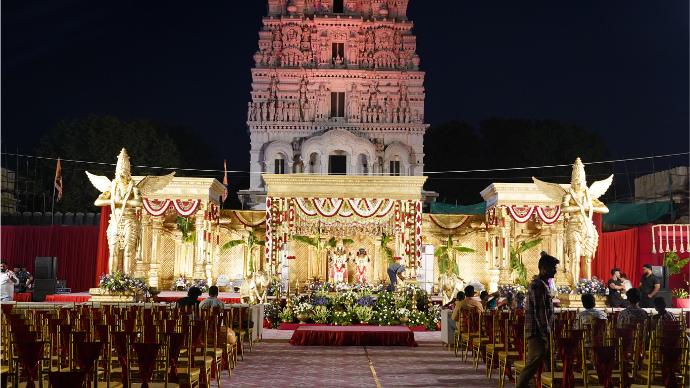 Temple wedding stage illuminated at night with the gopuram towering behind it