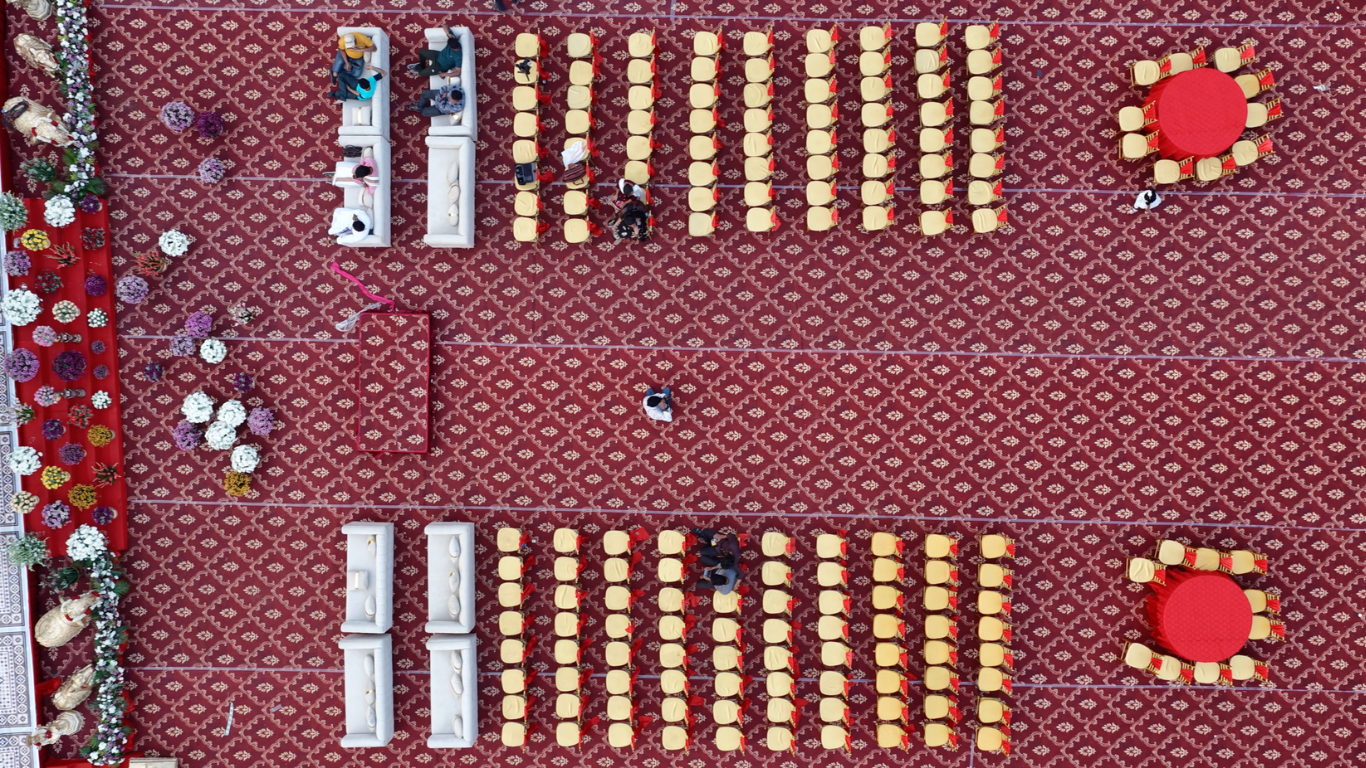 Aerial symmetrical view of guest seating with sofas, gold chairs and round tables