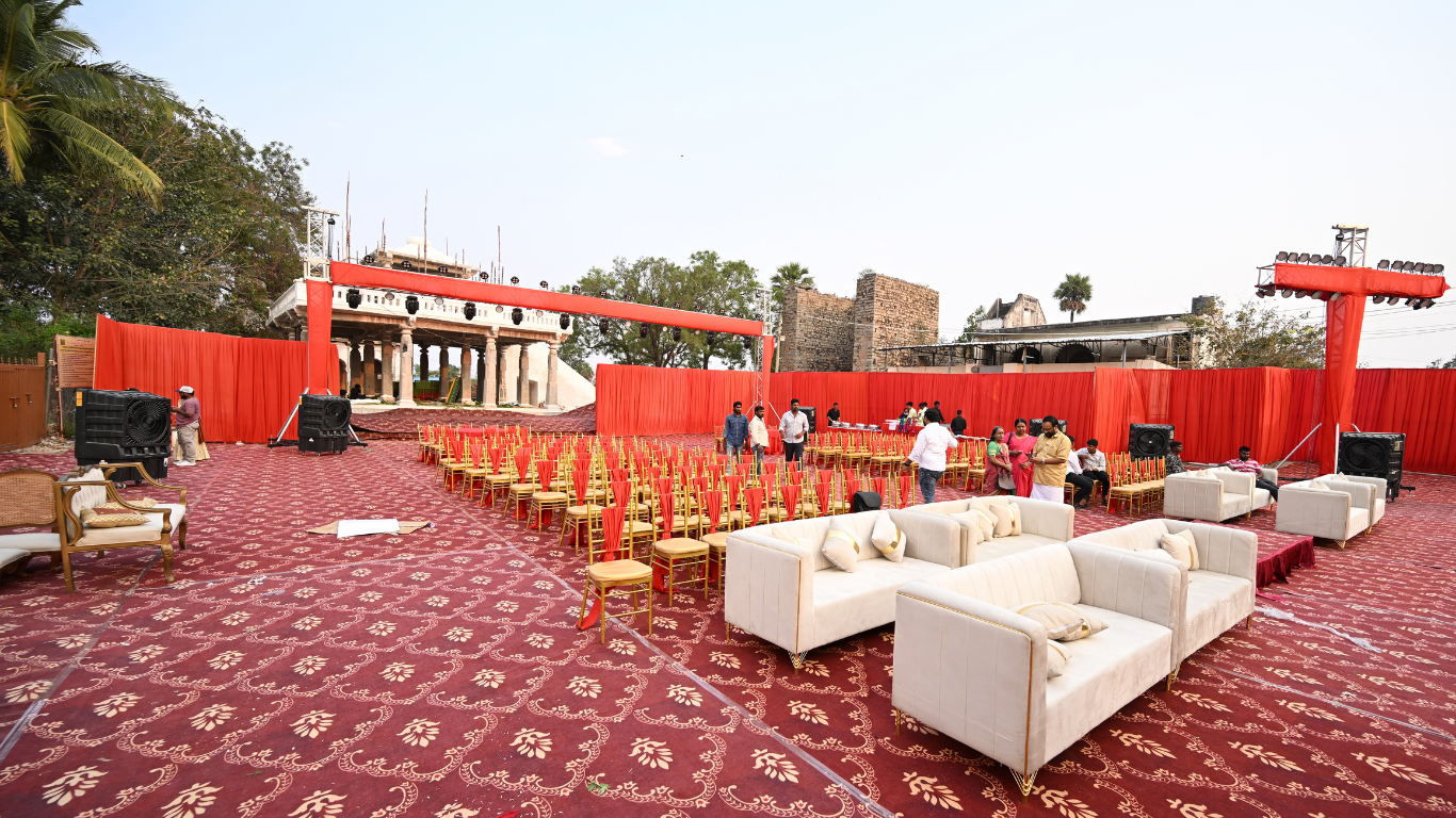 Side view of wedding seating area with white sofas and gold chairs facing the temple stage