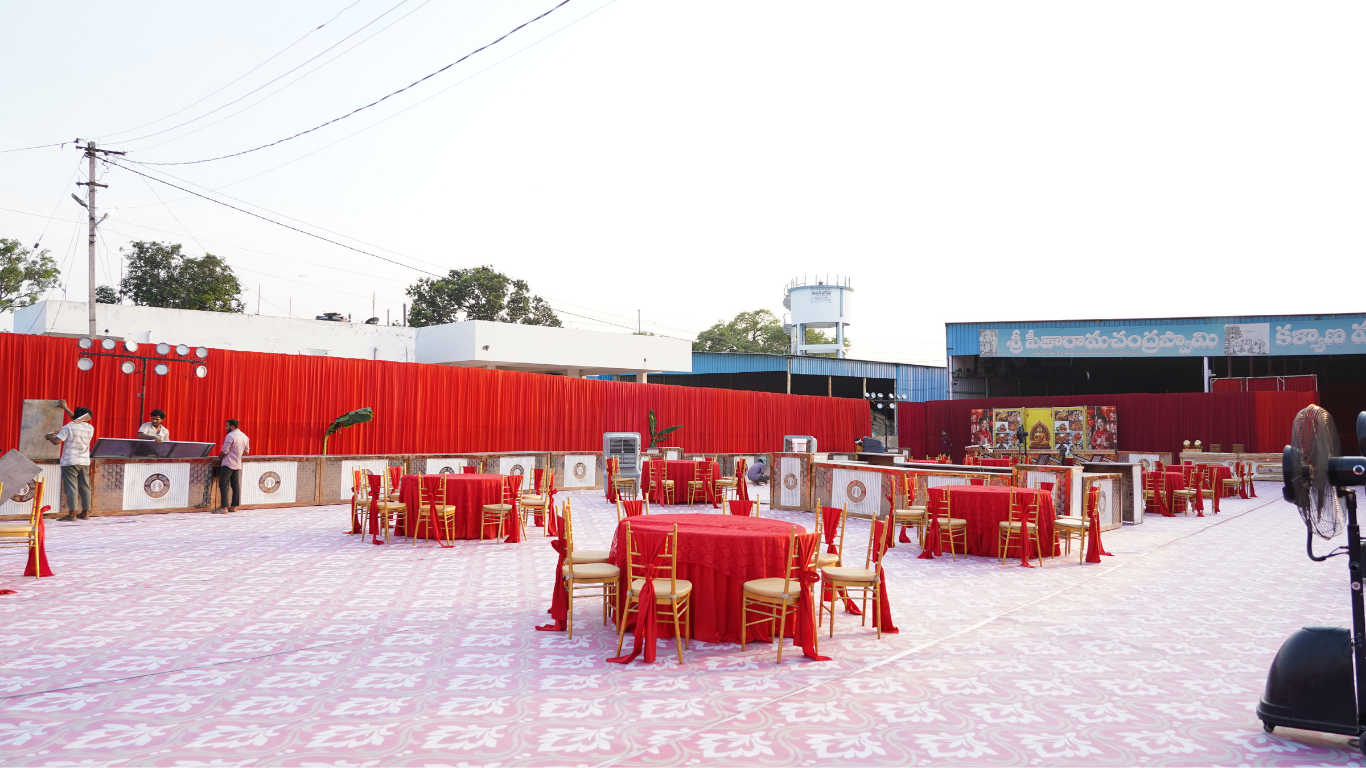 Outdoor reception area with round tables and red linens